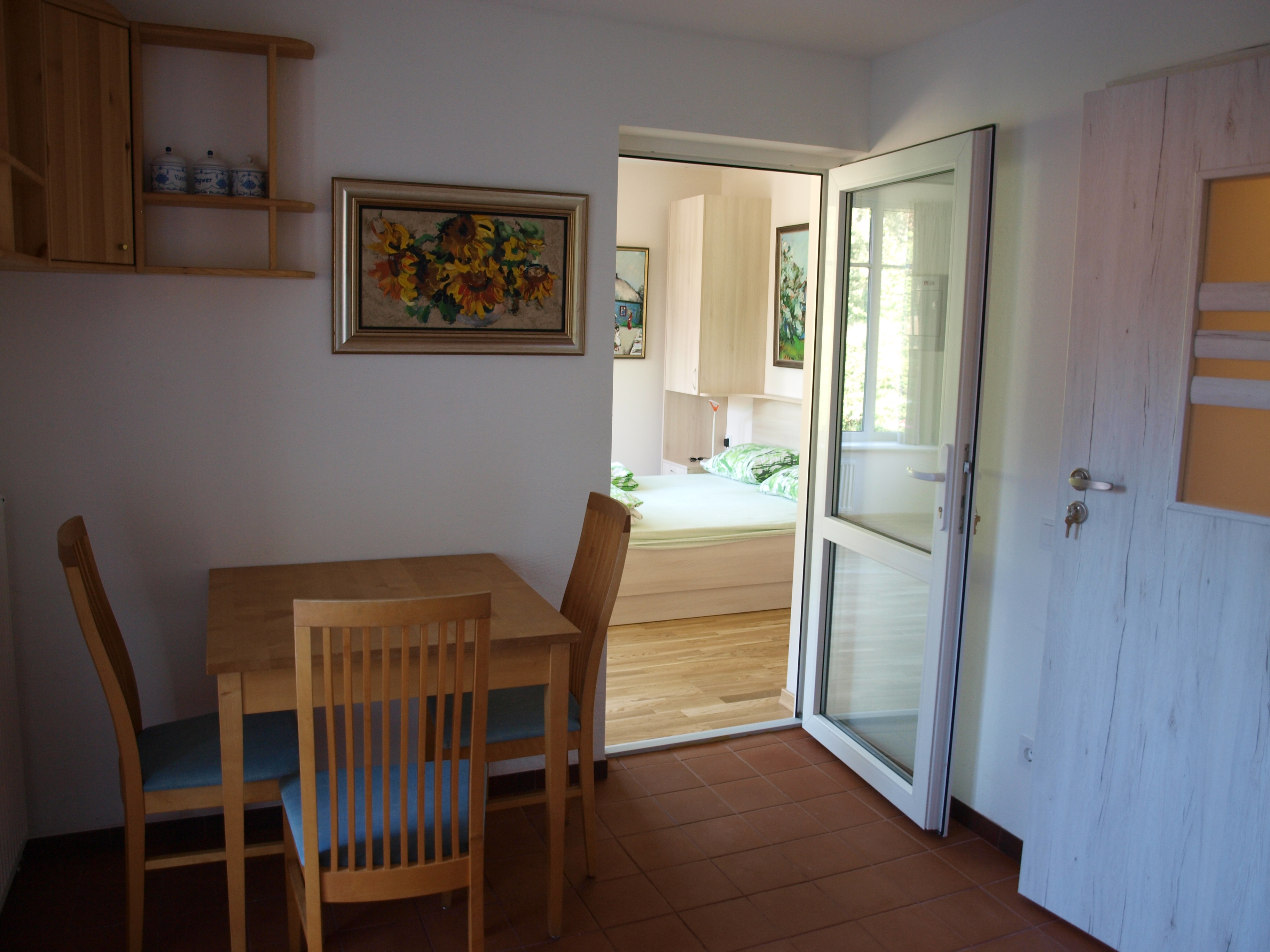 Apartment mit Terrasse – Essplatz und Blick ins Schlafzimmer
